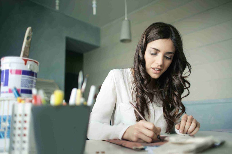 Mujer sentada en escritorio diseñando