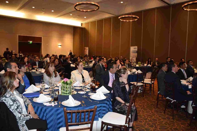 Evento UNITEC en salón de conferencias con asistentes atentos a la presentación