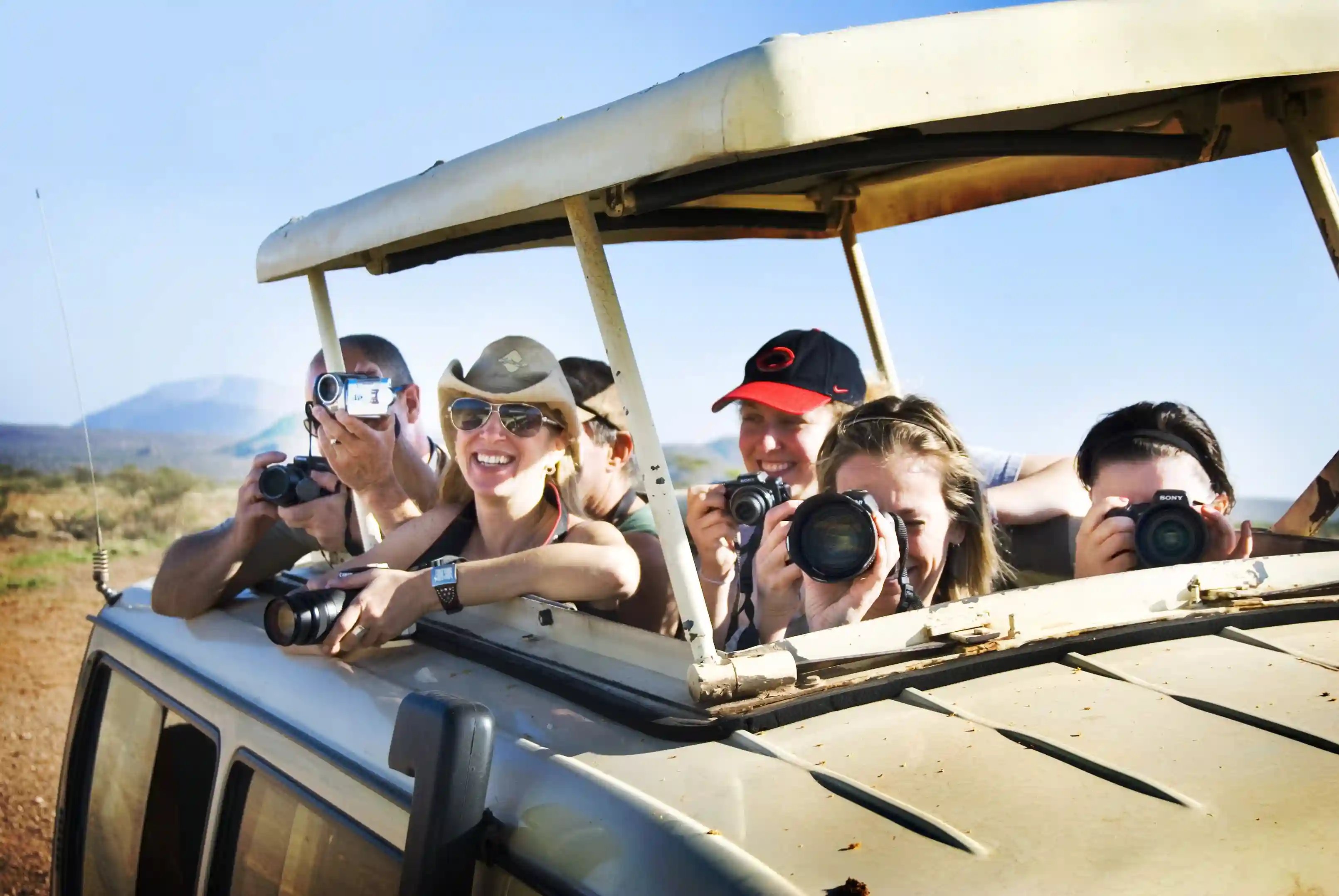 Grupo de turistas en un safari fotográfico capturando la fauna salvaje, experiencia esencial en fam trips para operadores turísticos.