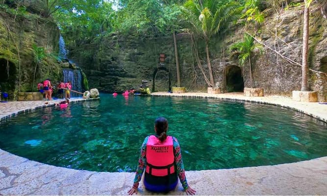 Vista de una alberca natural rodeada de vegetación en Xcaret, ideal para actividades de ecoturismo y relajación.