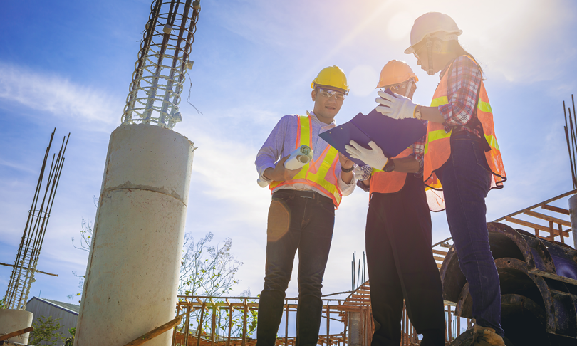 Ingeniero y arquitecto gestionando planos de construcción en proyecto de obra
