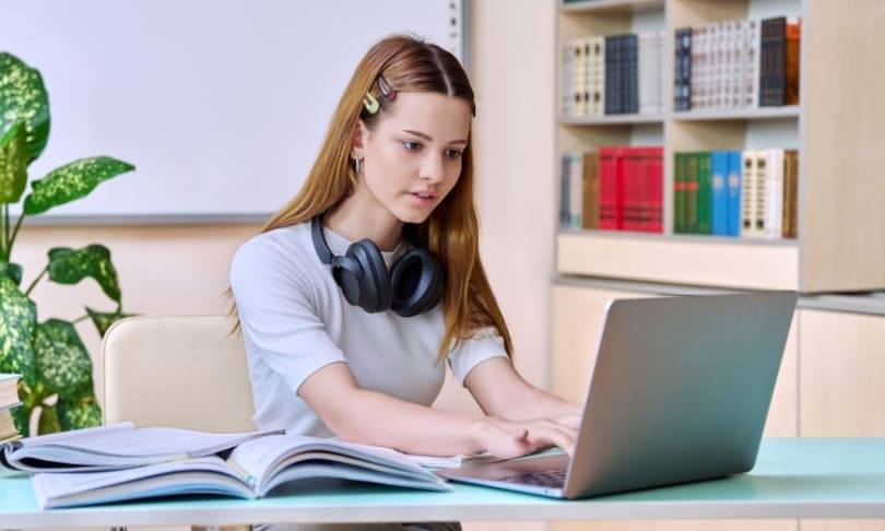 Aspirante estudiando con laptop y libros para la convocatoria UNAM 2025