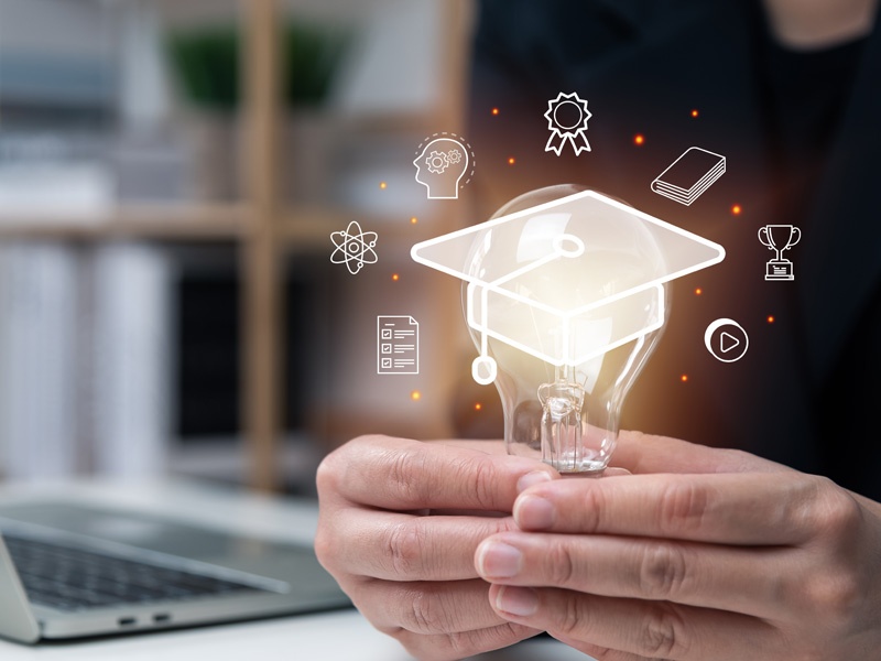 Concepto de innovación educativa con inteligencia artificial, mano sosteniendo bombilla con íconos de aprendizaje, tecnología y éxito académico