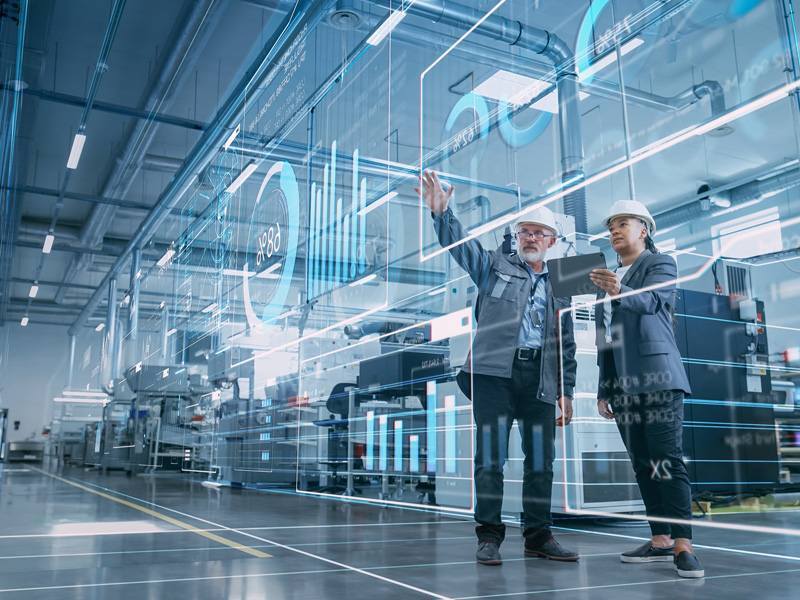 Ingenieros analizando datos en entorno industrial digitalizado con inteligencia artificial y visualización avanzada de gráficos en tiempo real