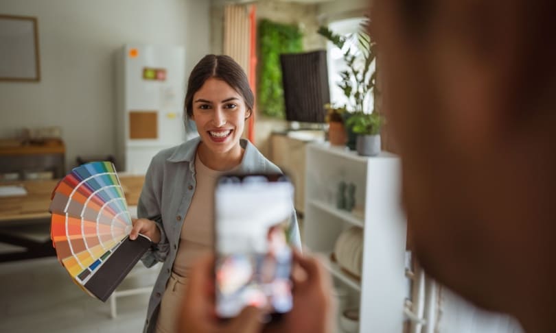 Diseñadora de interiores mostrando paleta de colores a cliente durante asesoría de diseño