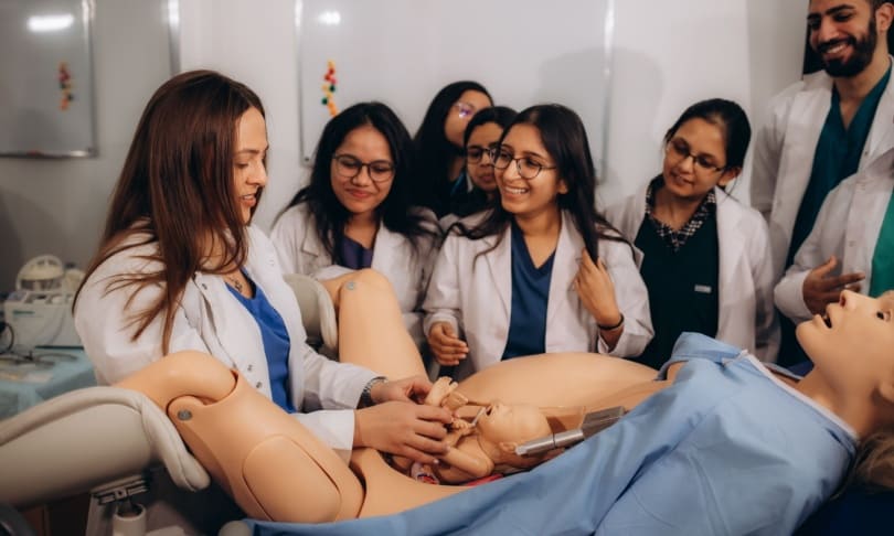Estudiantes de Ciencias de la Salud practicando un parto en un simulador clínico durante una sesión de aprendizaje práctico