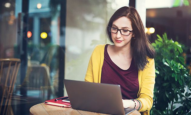 Estudiante joven tomando clases en línea con su laptop en cafetería