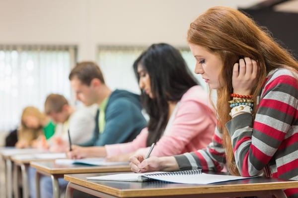 Estudiantes tomando apuntes en un salón de clases durante una sesión académica