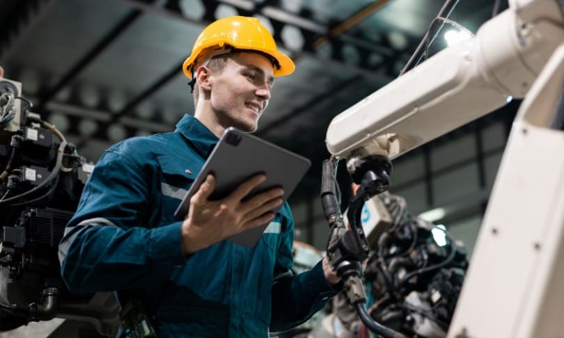 Ingeniero egresado de UNITEC en Mecatrónica supervisa brazo robótico en planta de automatización