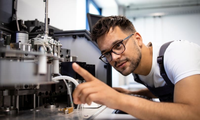 Ingeniero mecatrónico revisando maquinaria de precisión en laboratorio