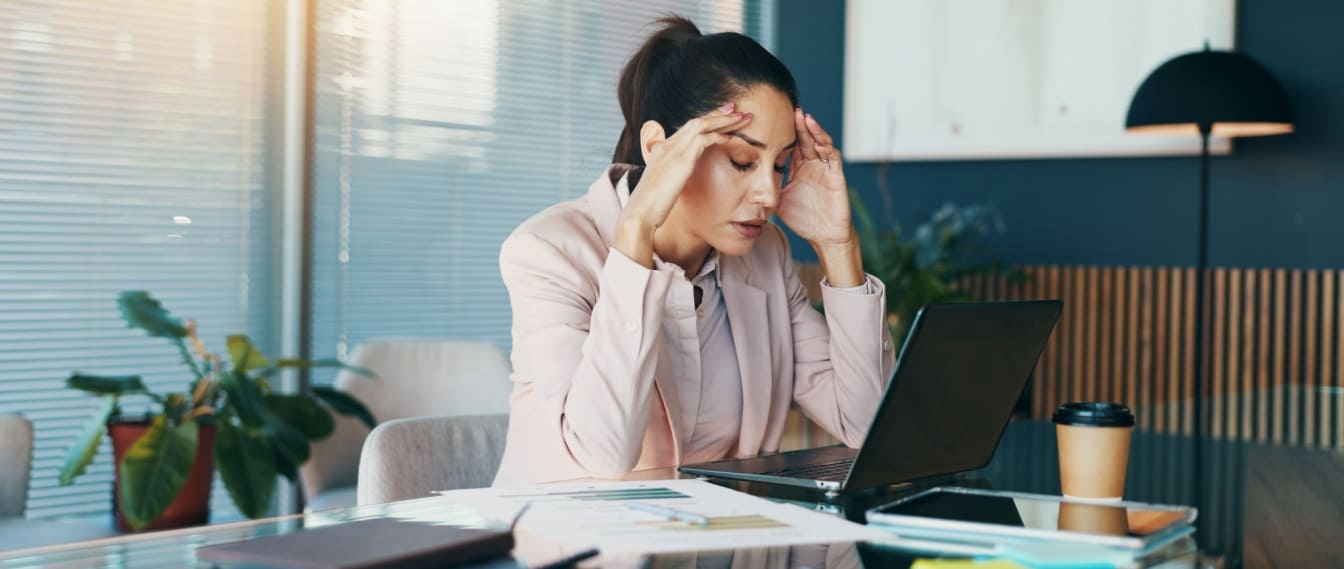 Profesional experimentando falta de motivación laboral y estrés en el trabajo mientras analiza tareas pendientes.