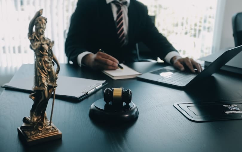 Licenciado en derecho frente a su escritorio tomando nota en su escritorio