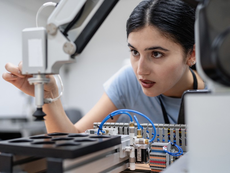 Estudiante con estilo de aprendizaje kinestésico trabajando en laboratorio con equipo robótico