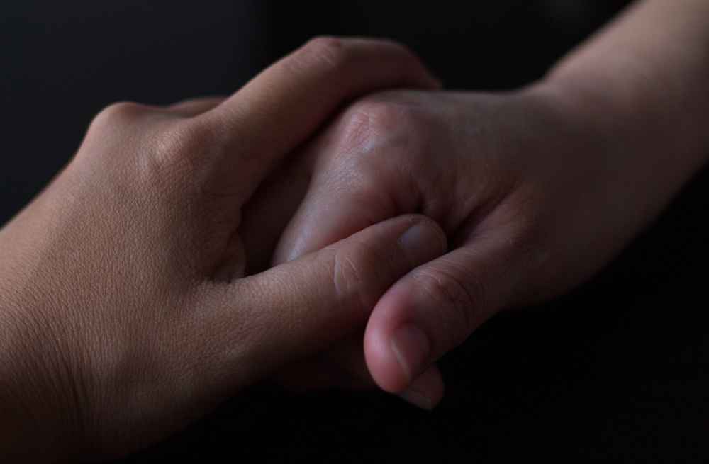 Manos entrelazadas mostrando empatía y habilidades clave de la carrera de psicología.