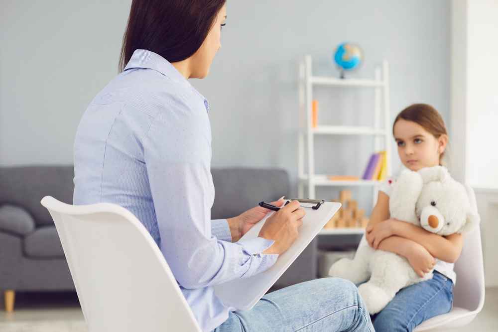 Psicóloga infantil atendiendo a niña en sesión, especialización dentro de la carrera de psicología.