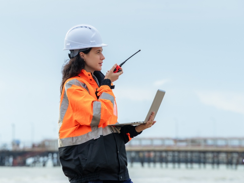 Ingeniera en telecomunicaciones supervisando sistemas de comunicación y transmisión de datos en campo