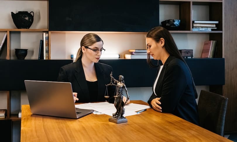 licenciadas en derecho conversando sobre un caso en sala de juntas
