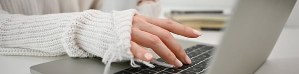 Mano tecleando en laptop durante estudio de carrera en línea desde casa