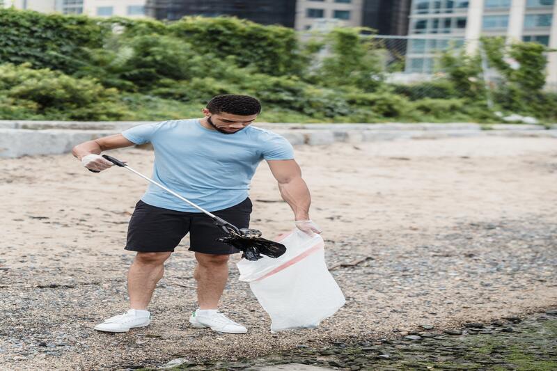 Hombre recogiendo basura y depositandola en una bolsa