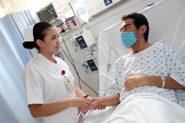 Licenciada en enfermeria cuidando a un paciente en camilla